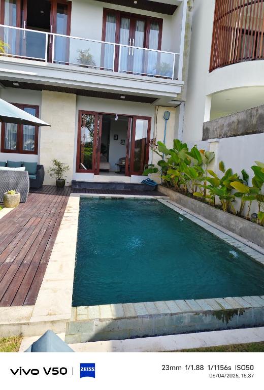 a swimming pool in front of a house at villa nusantara ungasan in Uluwatu