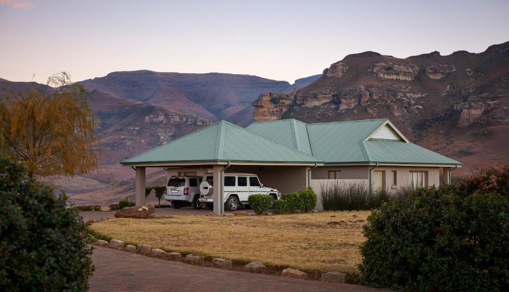 een huis met een vrachtwagen geparkeerd voor een berg bij Dynasty Red Mountain Ranch in Clarens