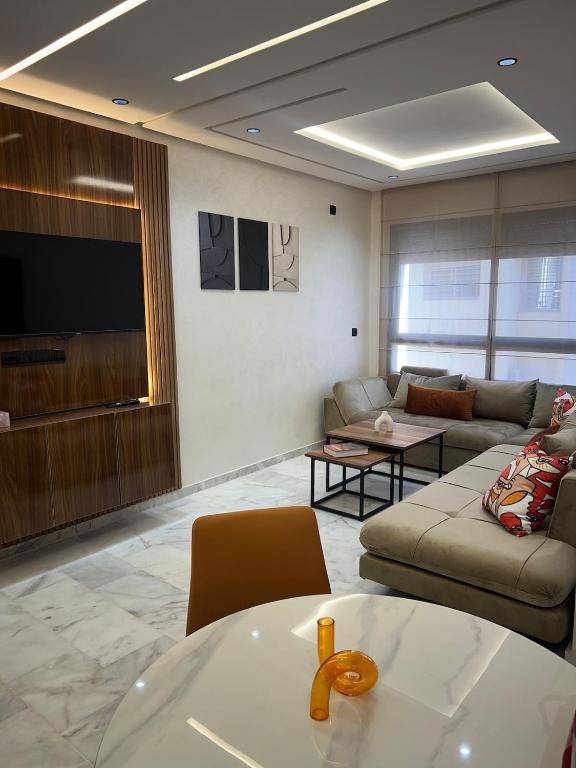 a living room with a couch and a tv at Very nice modern air-conditioned apartment in Fez in Fès