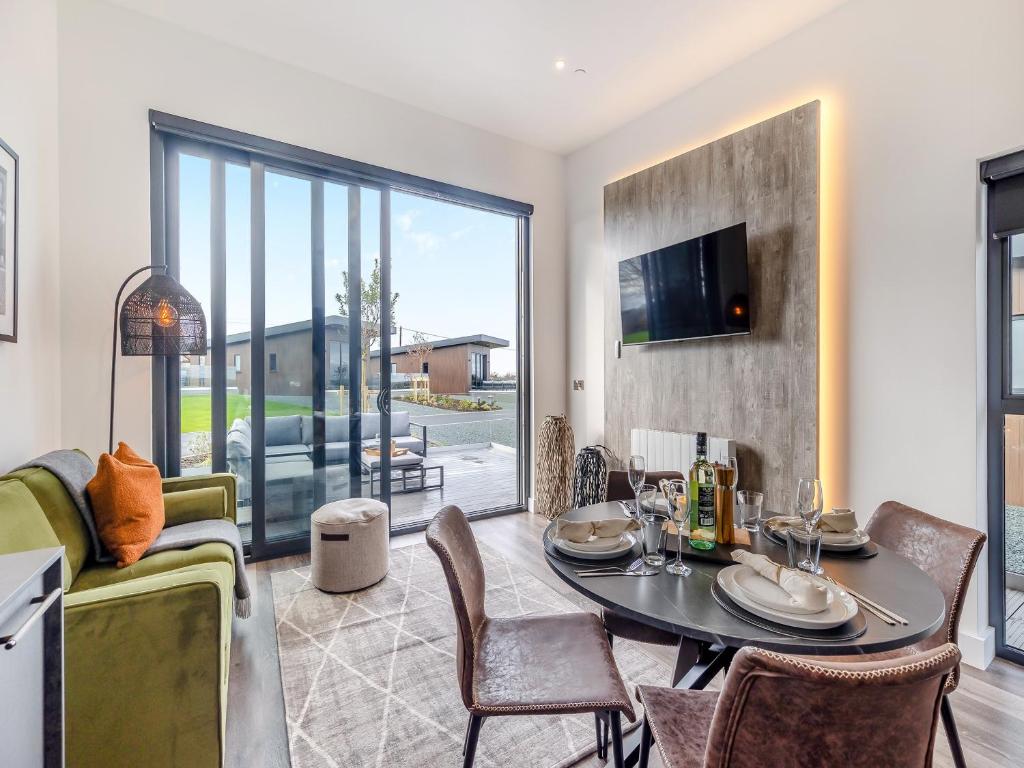 a living room with a table and chairs and a tv at Lodge Six - Uk42798 in Llangefni