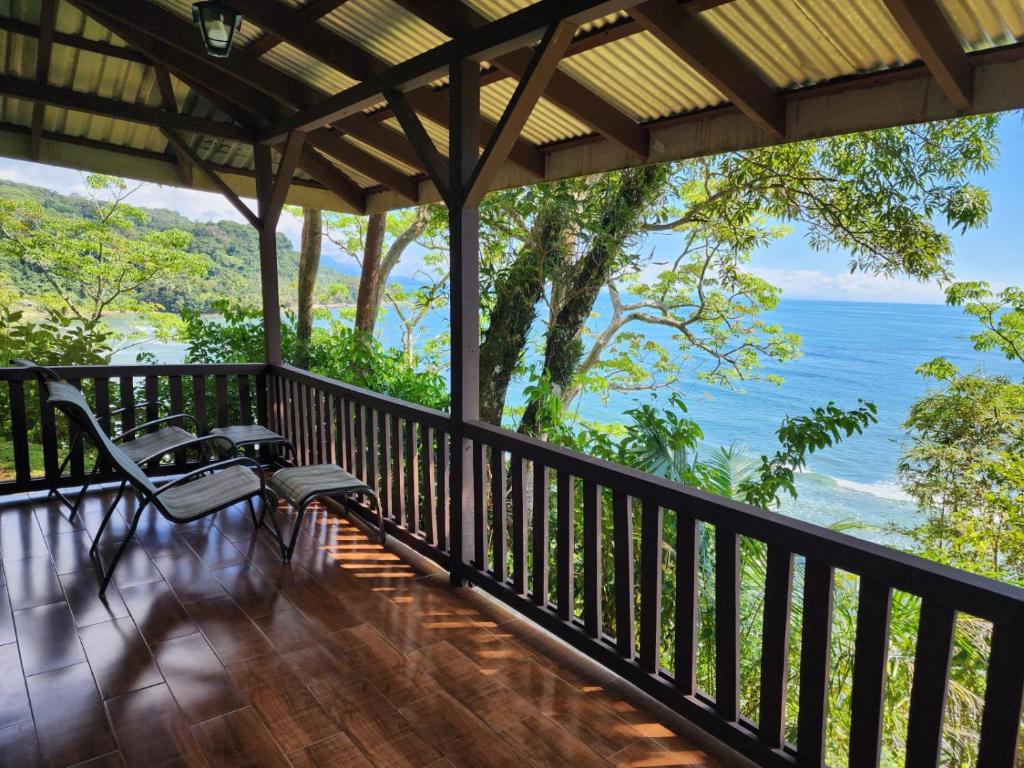 a screened in porch with a view of the ocean at Cabinas La Parcela in Dominicalito