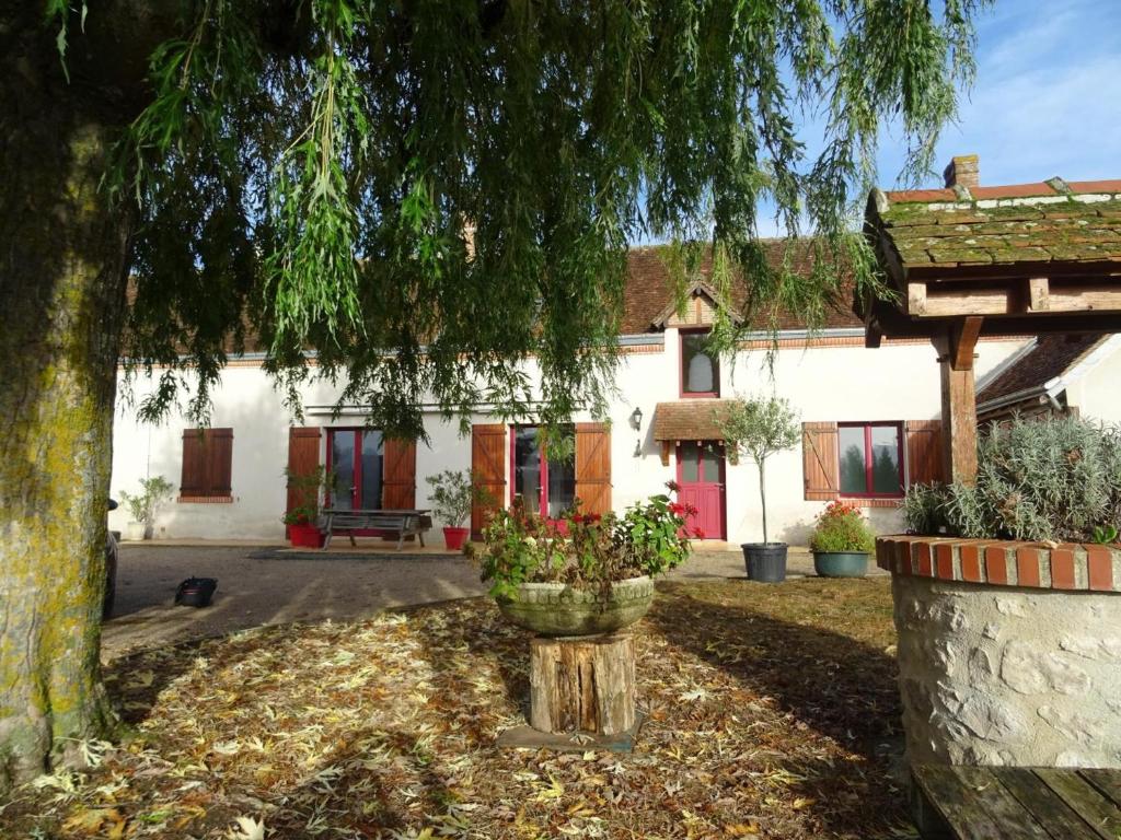 une maison avec un arbre devant dans l'établissement Charmante Ferme Restaurée avec Jardin Clos, Proche des Châteaux, Idéale Familles et Nature - FR-1-491-365, à Mont-près-Chambord