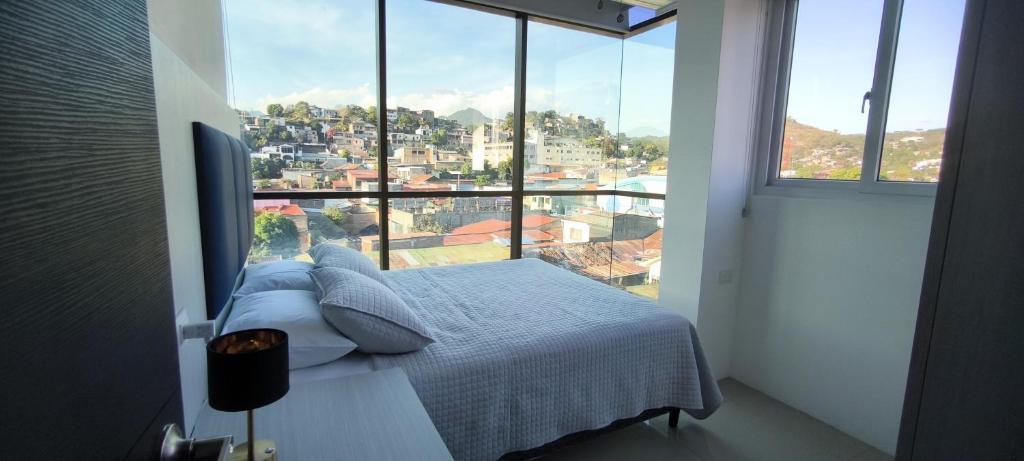 ein Bett in einem Zimmer mit einem großen Fenster in der Unterkunft Apartamento en el centro de Matagalpa in Matagalpa
