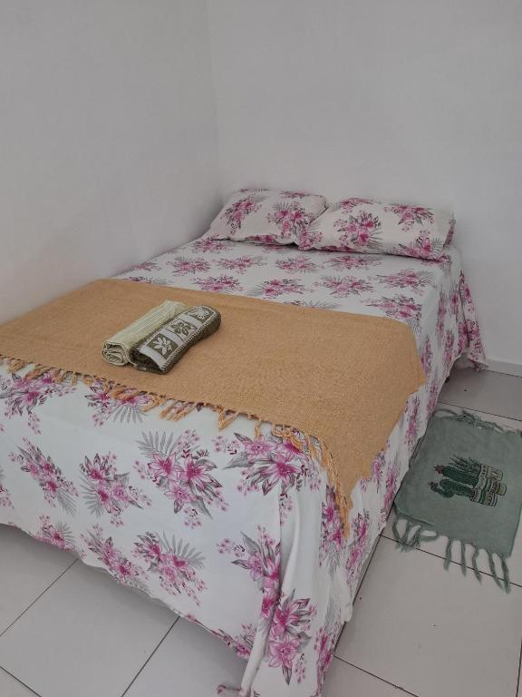 a bed with a remote control on top of it at Quarto Confortável no Centro - Bela Ilha House in São Luís