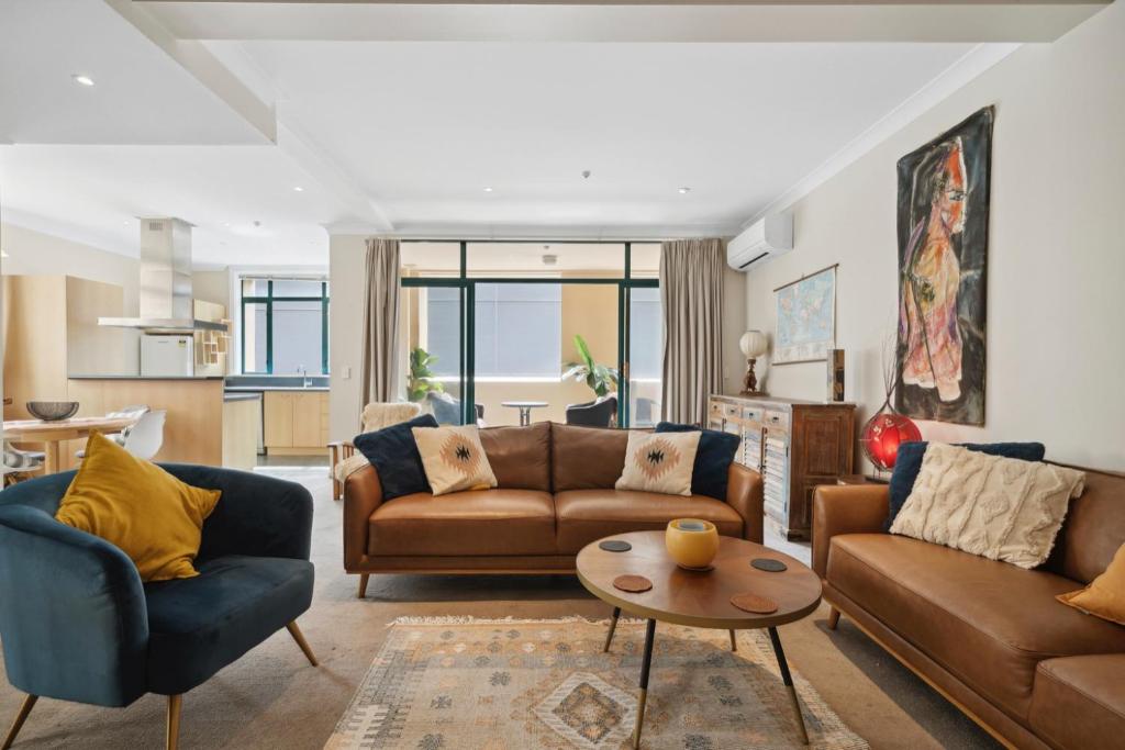 a living room with two couches and a table at Spacious, 2 Bed, 2 Bath Central City Retreat in Wellington