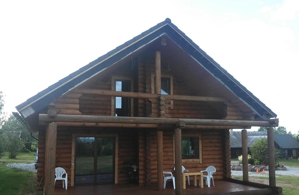 a log cabin with two chairs and a table at Järve Holiday Village in Kodavere