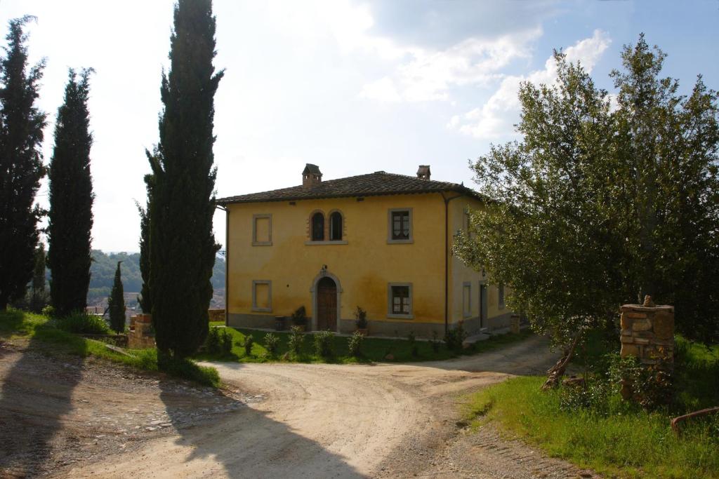 a large yellow house on a dirt road at Tenuta Il Tresto in Poggibonsi