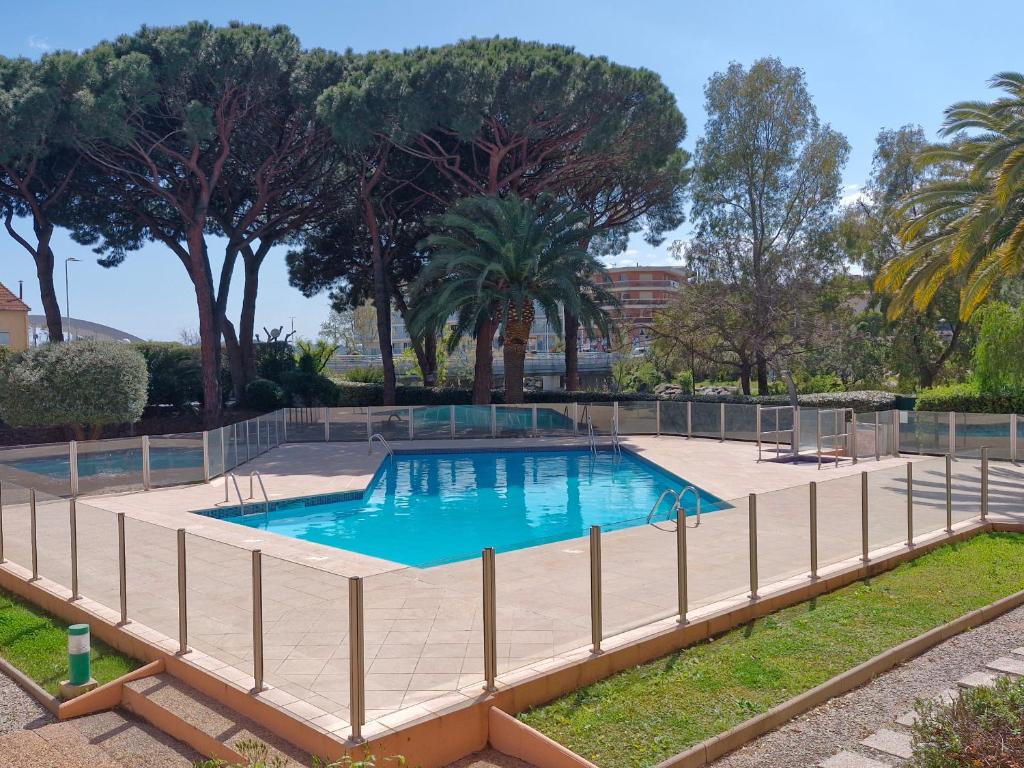 une piscine entourée d'une clôture dans l'établissement Appartement 2 pièces climatisé, piscine, centre-ville, parking privé, animal accepté, Sainte-Maxime - FR-1-780-18, à Sainte-Maxime