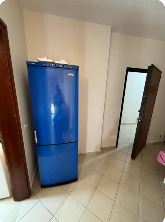a blue refrigerator in the corner of a room at Apartments in Durrës 3 min walk from the beach in Durrës