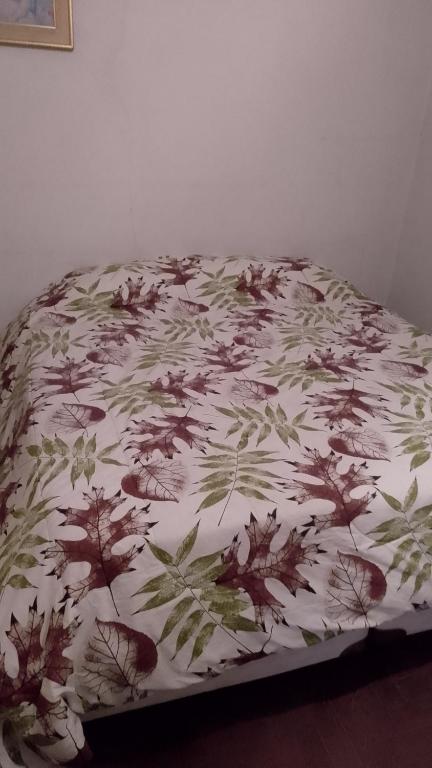 a bed with a floral comforter on top of it at Residencia "Libertad" in San Andrés