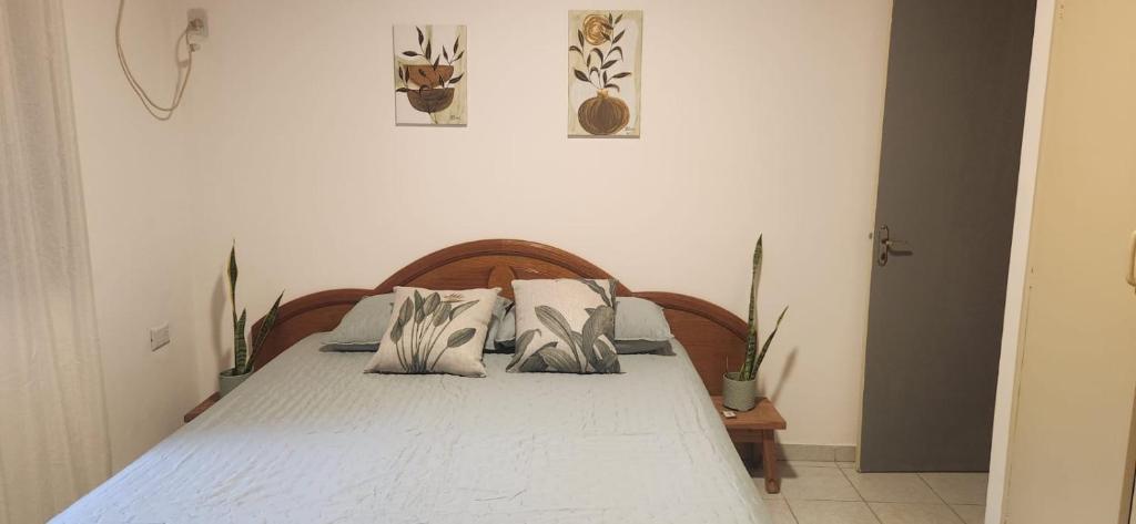una camera da letto con un letto con lenzuola e cuscini bianchi di Alojamiento en Puerto Iguazú, Alojamiento en Cataratas, 2 Habitaciones a Puerto Iguazú