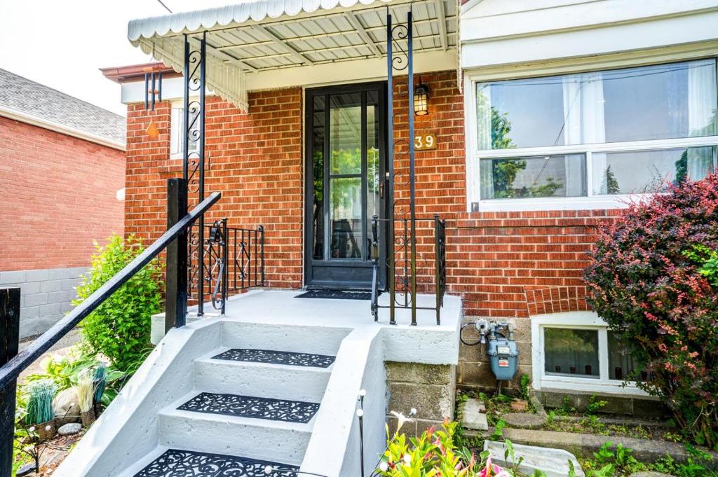 een stenen huis met een trap naar de voordeur bij 2 Bedroom East-York bungalow in Toronto