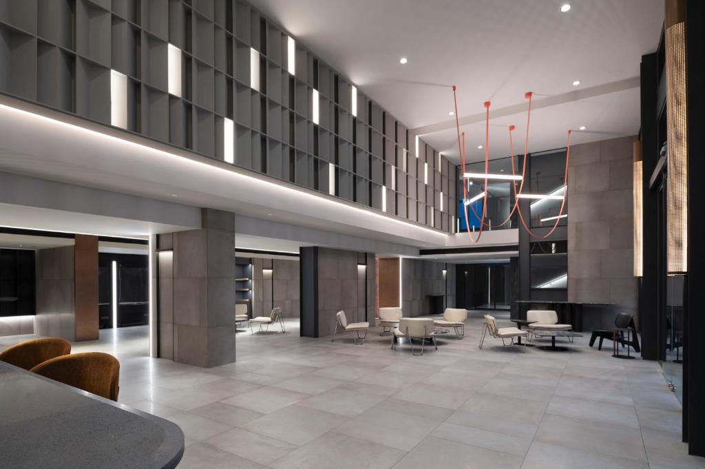 A spacious contemporary lobby with lounge seating, tables and sculptural lighting.