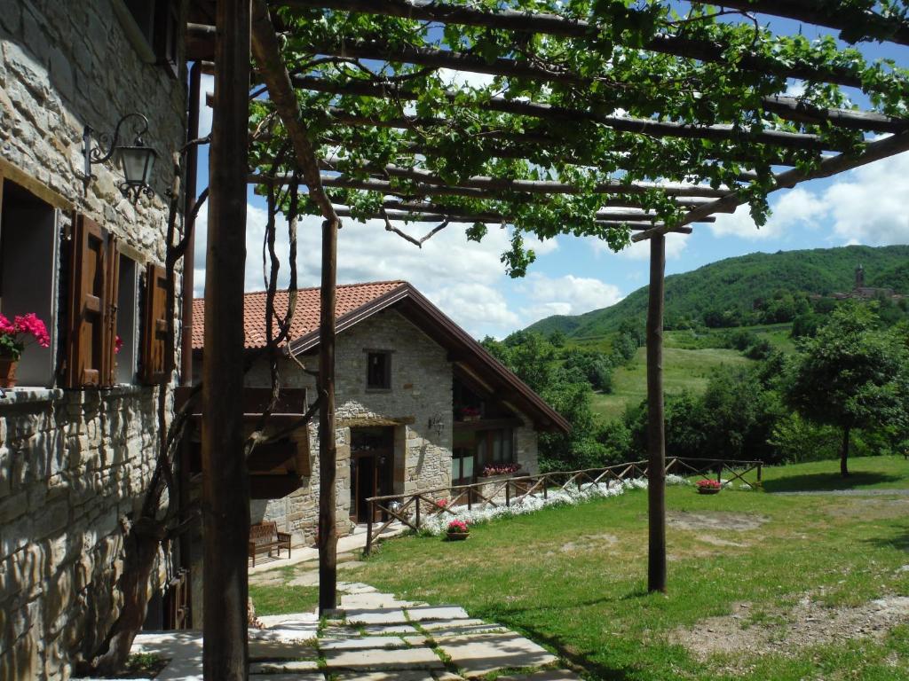 a stone house with a pergola next to a building at Agriturismo Ca' de' Magnani in Baragazza