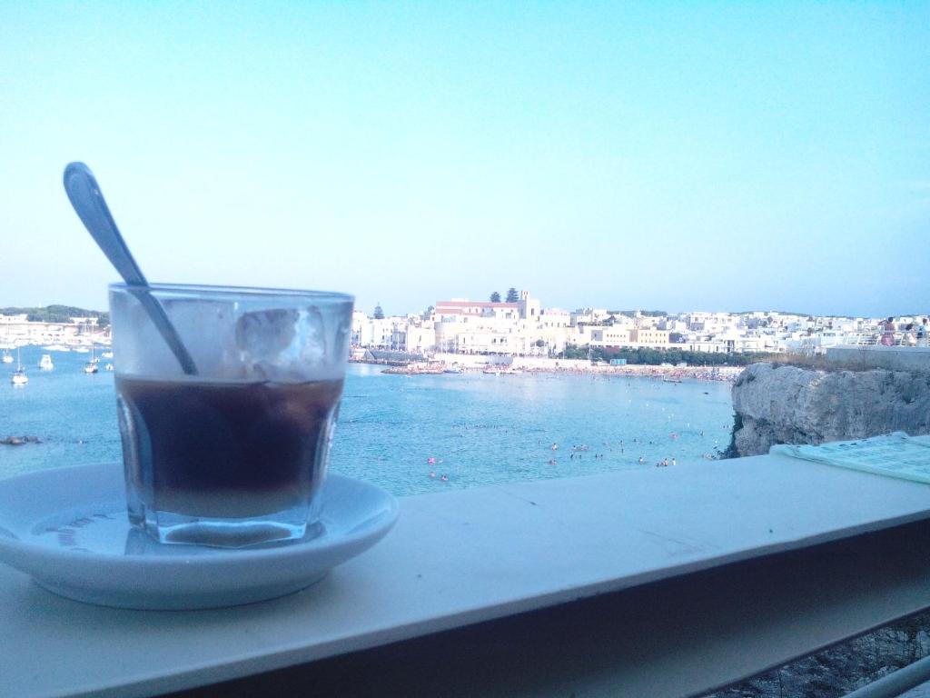 ein Getränk auf einem Tisch mit Blick auf das Wasser in der Unterkunft Casa Annamaria in Otranto