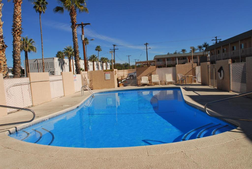 una gran piscina azul con palmeras en el fondo en Stone Inn Extended Stay U of A en Tucson