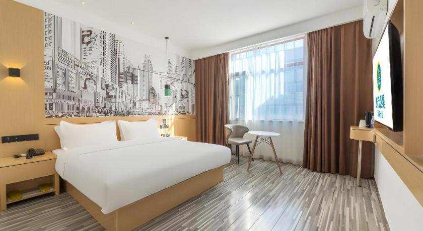 ein Hotelzimmer mit einem Bett und einem Fernseher in der Unterkunft City Comfort Inn Nanchang Tengwang Pavilion Metro Station in Nanchang