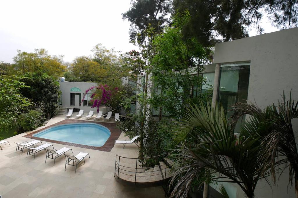 a swimming pool with chairs and a house at Casa Tepoztlán in Tepoztlán