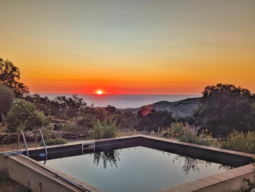 Una piscina con una puesta de sol al fondo en Mas d'en Selve Domaine d'exception avec vue Mer, en Argelès-sur-Mer