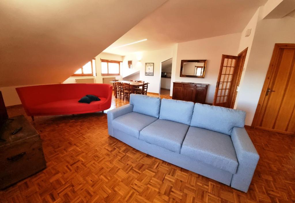 a living room with a couch and a red chair at Casa Michetti in Castel di Sangro