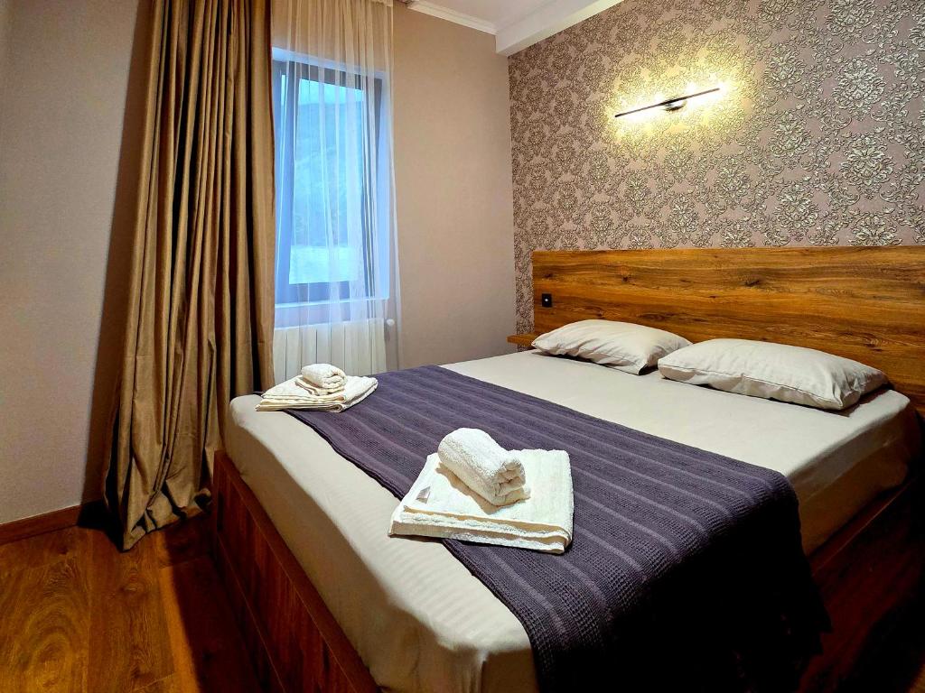 a bedroom with a large bed with towels on it at Guest house "Soulmate" in Ambrolauri
