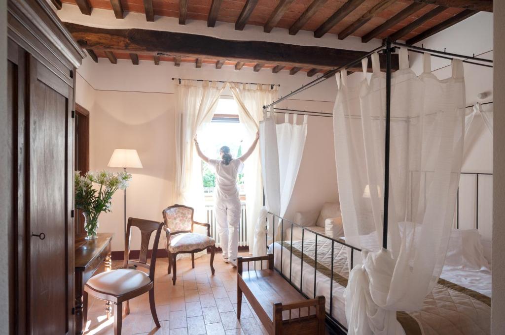 a room with a bed, chairs, and a table in it at B&B L'orto Delle Terme in Bagno Vignoni
