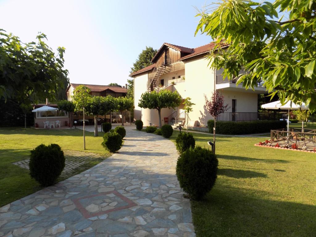 a walkway in front of a house with trees at Alisachni in Paralia Panteleimonos