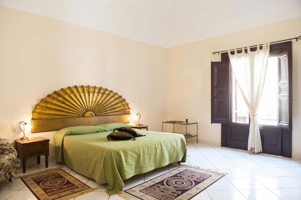 ein Schlafzimmer mit einem großen Bett und einem großen Fenster in der Unterkunft Case D'Anna in Castellammare del Golfo