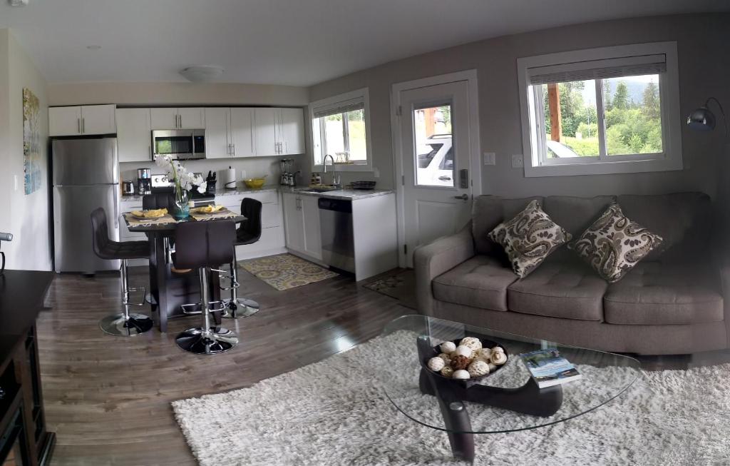 a living room with a couch and a kitchen at Cowichan Calling in Lake Cowichan