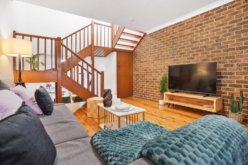 a living room with a couch and a tv at 2-Bedroom House-Near city center Good for 6 Guests in Sydney