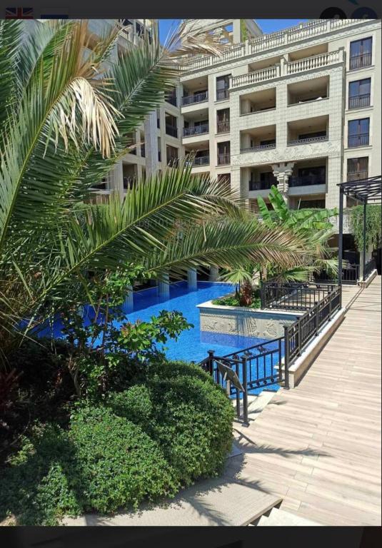 a swimming pool next to a large building at Argisht complex apart 208 in Golden Sands