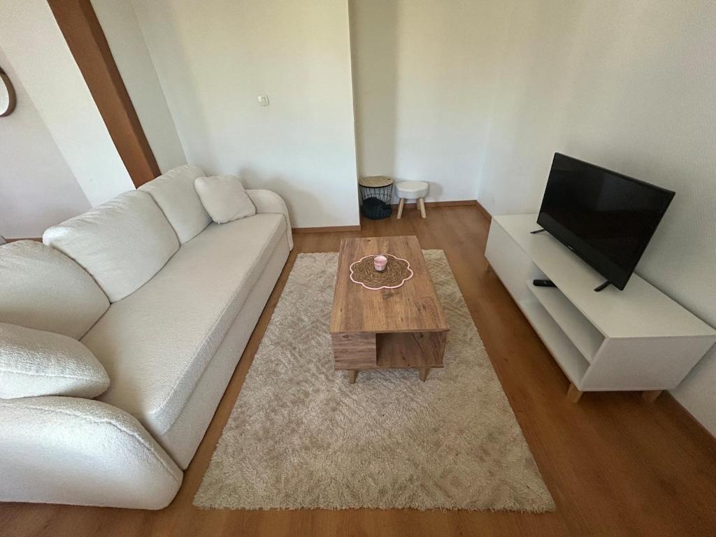 a living room with a white couch and a coffee table at appartement cosy tout équipé avec balcon in Châlette-sur-Loing