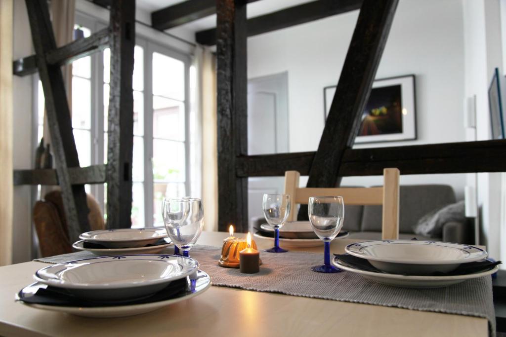 a table with plates and glasses and a candle on it at L'Atelier in Strasbourg