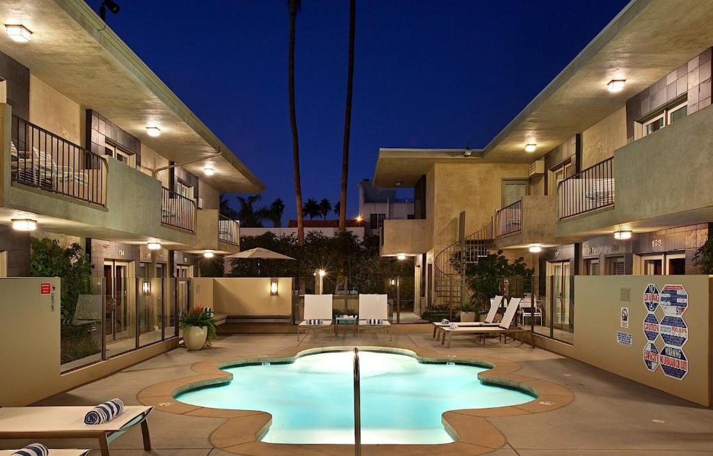 a pool in a courtyard of a building at night at 7 Springs Inn & Suites in Palm Springs