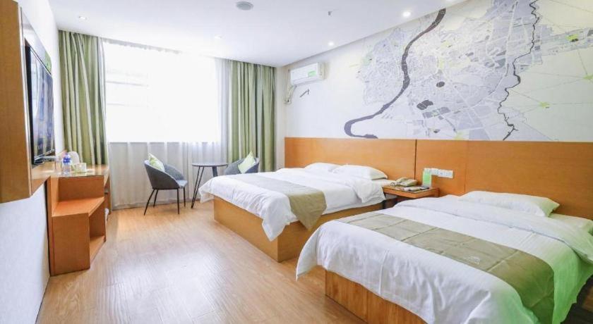 ein Hotelzimmer mit 2 Betten und einer Karte an der Wand in der Unterkunft Vatica HeFei Baishuiba BHG Hotel in Hefei