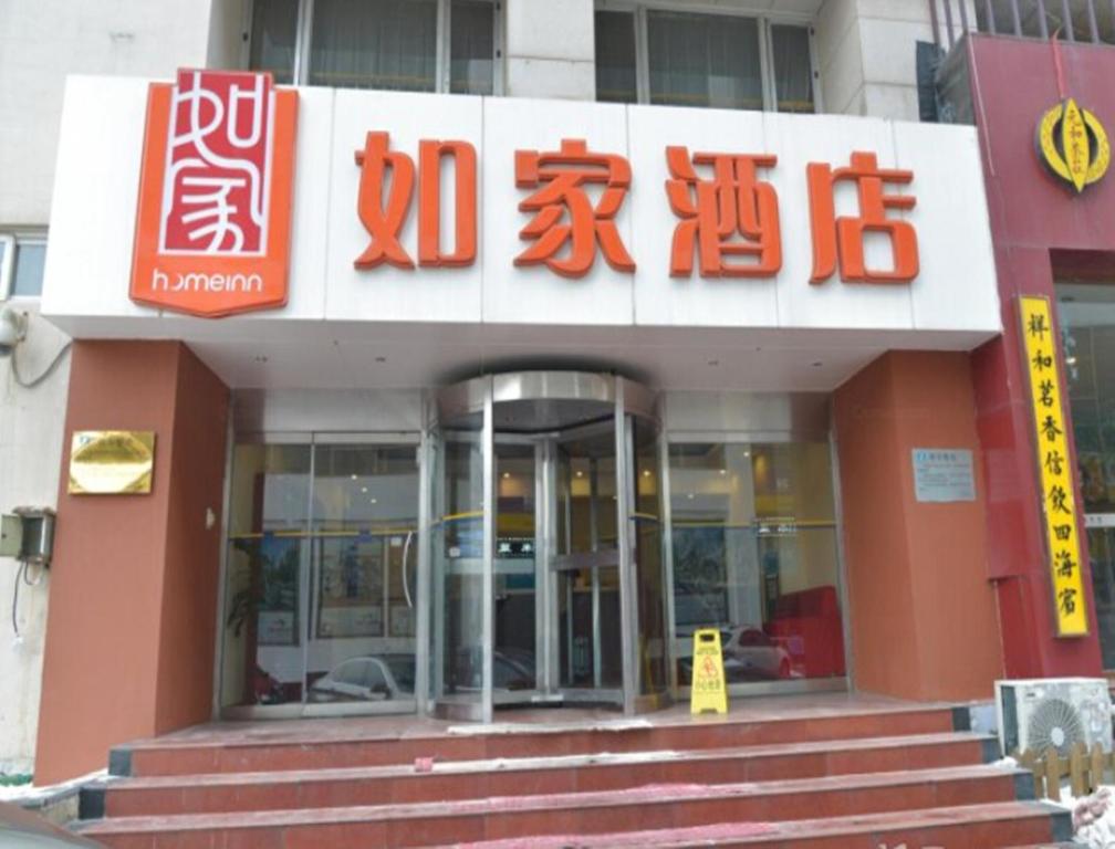 un bâtiment avec un panneau à l'avant dans l'établissement Home Inn Tianjin Developmental District, à Binhai