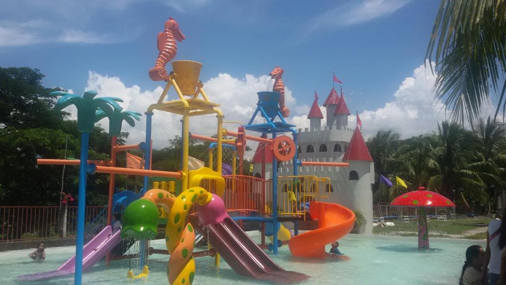 einen Spielplatz vor einem Schloss Disney in der Unterkunft Gazebo Pools and Restaurant in Cabadbaran