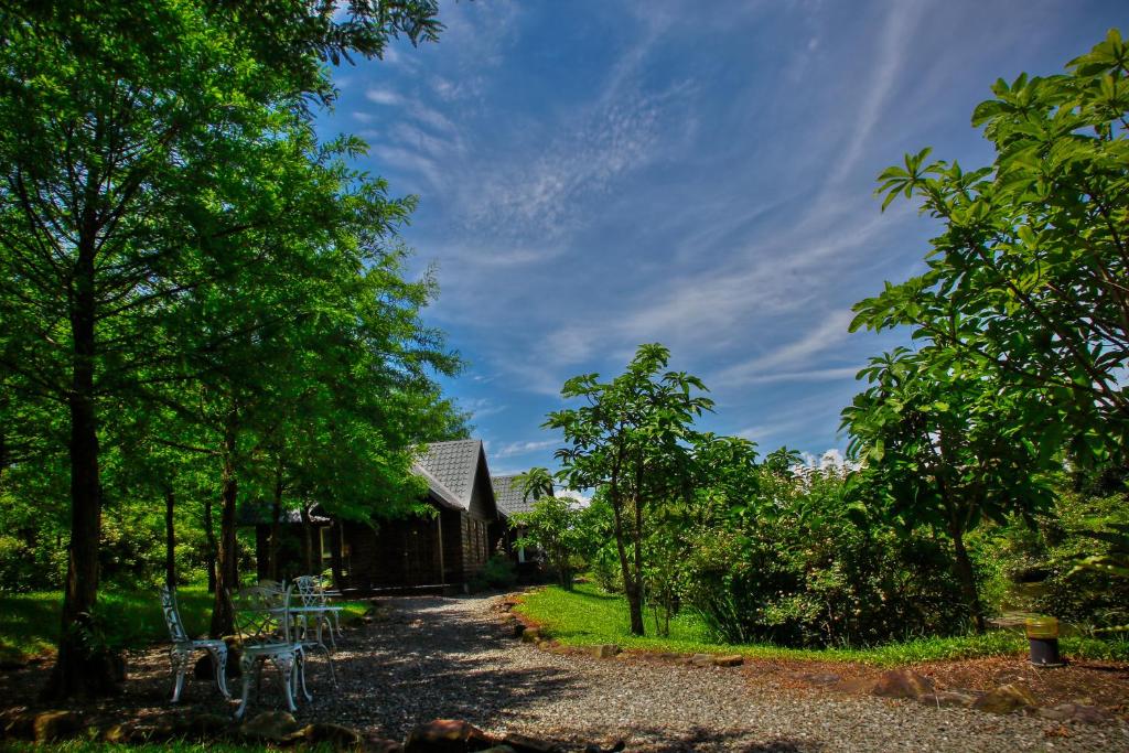 ein Haus mit einer Schotterstraße neben Bäumen in der Unterkunft Green Forest Villa in Yilan