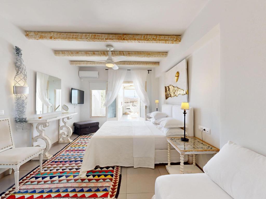 a white room with four beds and a couch at Speires suites in Irakleia
