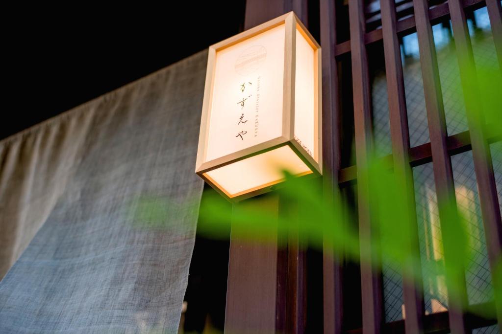 a clock hanging on the side of a fence at Kazueya in Kanazawa