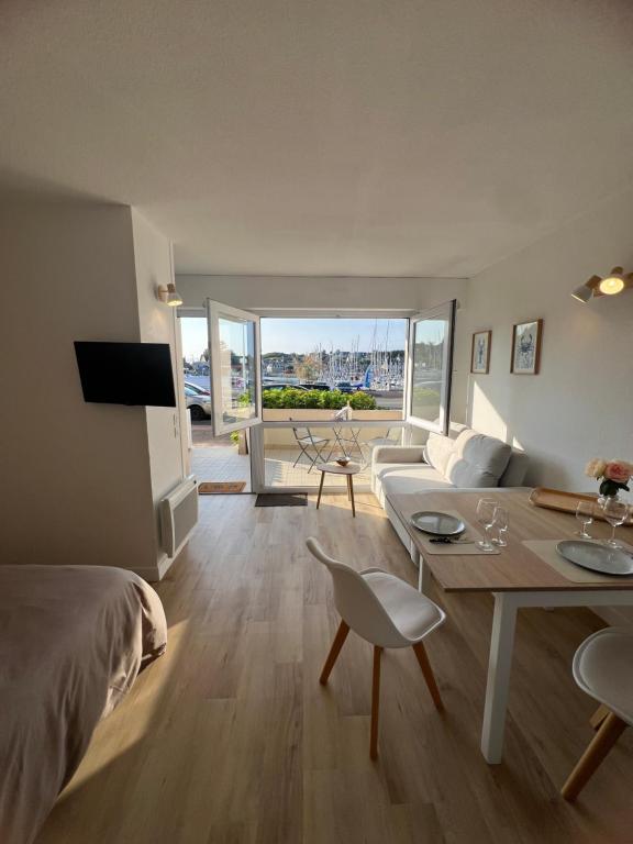 a bedroom with a bed and a living room with a table at Le 29 à Dahouët in Pléneuf-Val-André