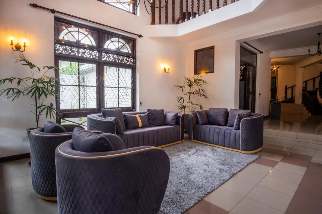 a living room with couches and tables and windows at Tribe Hostel in Kandy
