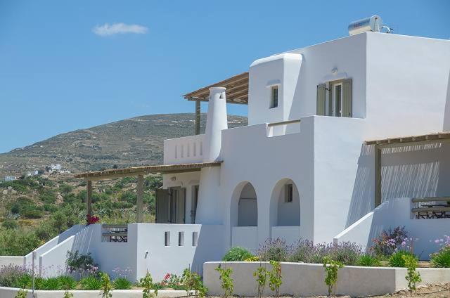 a white house with a hill in the background at Aerides Villas in Naxos Chora