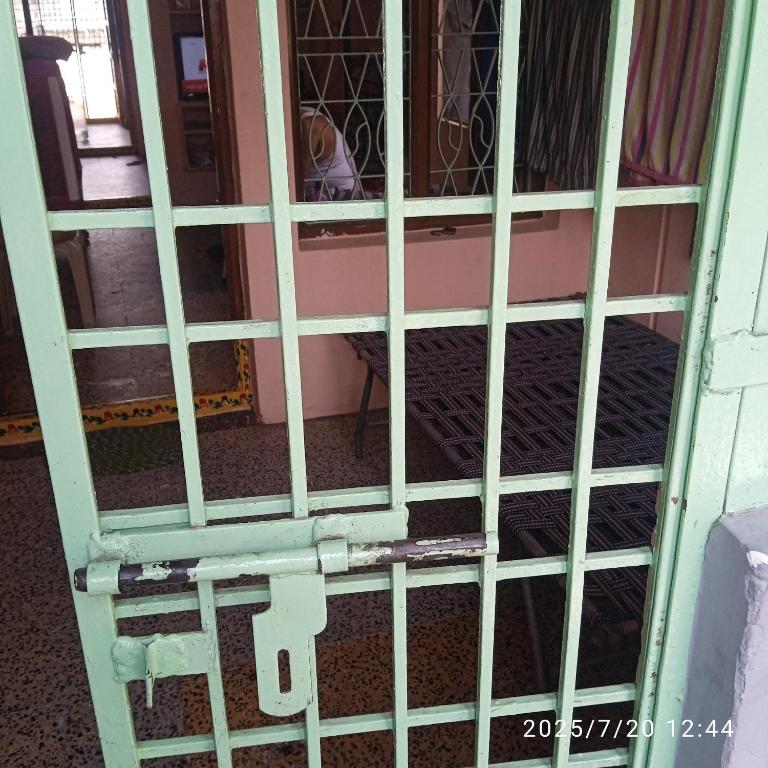 an open door of a prison cell at Sai Home Stay in Narasaraopet