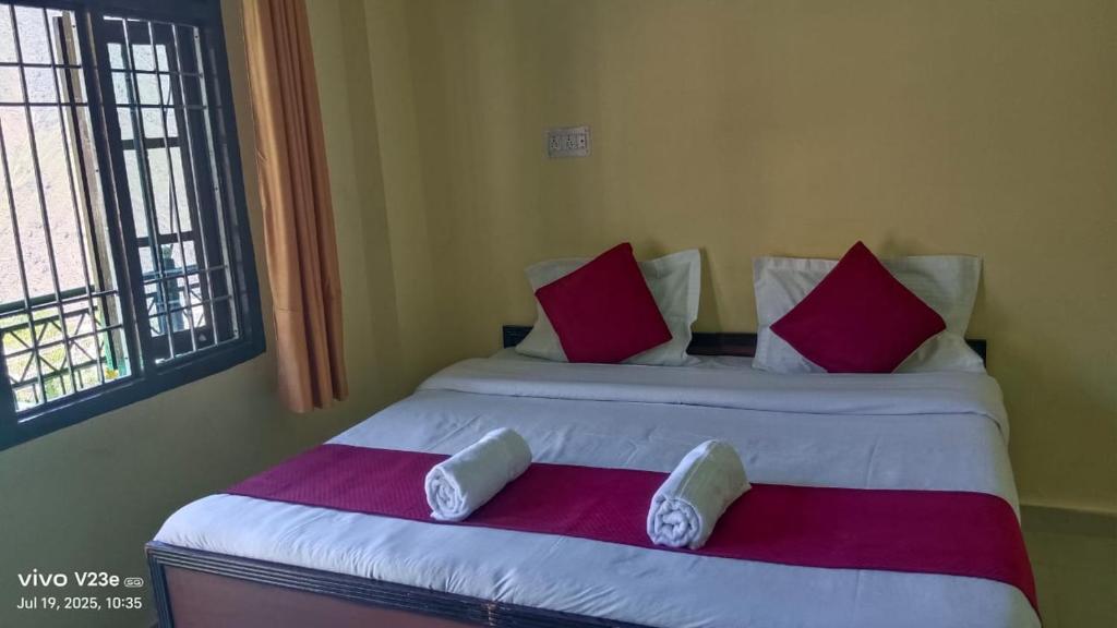 a bedroom with a large bed with red and white pillows at Hotel Nanak bharmour manimahesh in Brāhmaur
