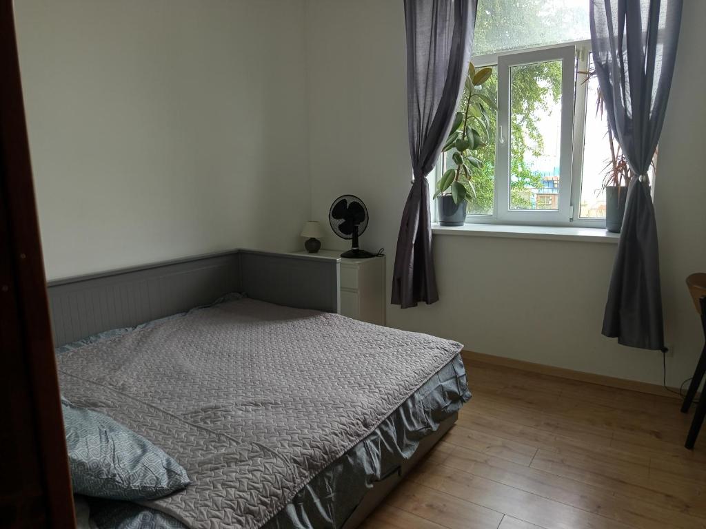 a bedroom with a bed and a window at Canalside Studio Loft in Liepāja
