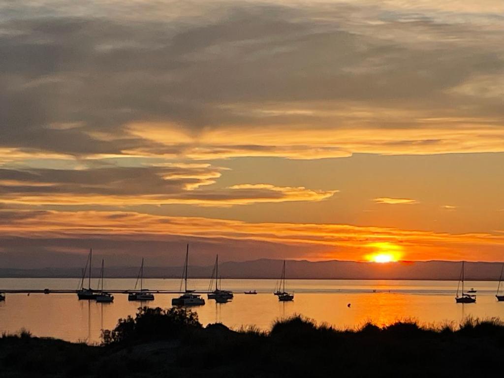 - un groupe de bateaux sur l'eau au coucher du soleil dans l'établissement Port Camargue plage sud, Très bel appartement avec vue mer, au Grau-du-Roi