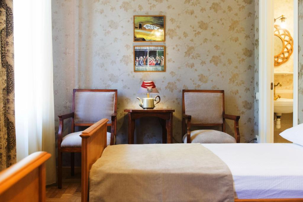 um quarto com 2 cadeiras, uma mesa e uma cama em Bloom Boutique Hotel em Tbilisi