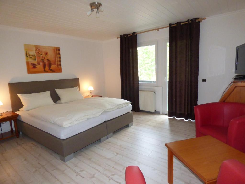 ein Schlafzimmer mit einem Bett und ein Wohnzimmer in der Unterkunft Hotel Diele in Detmold