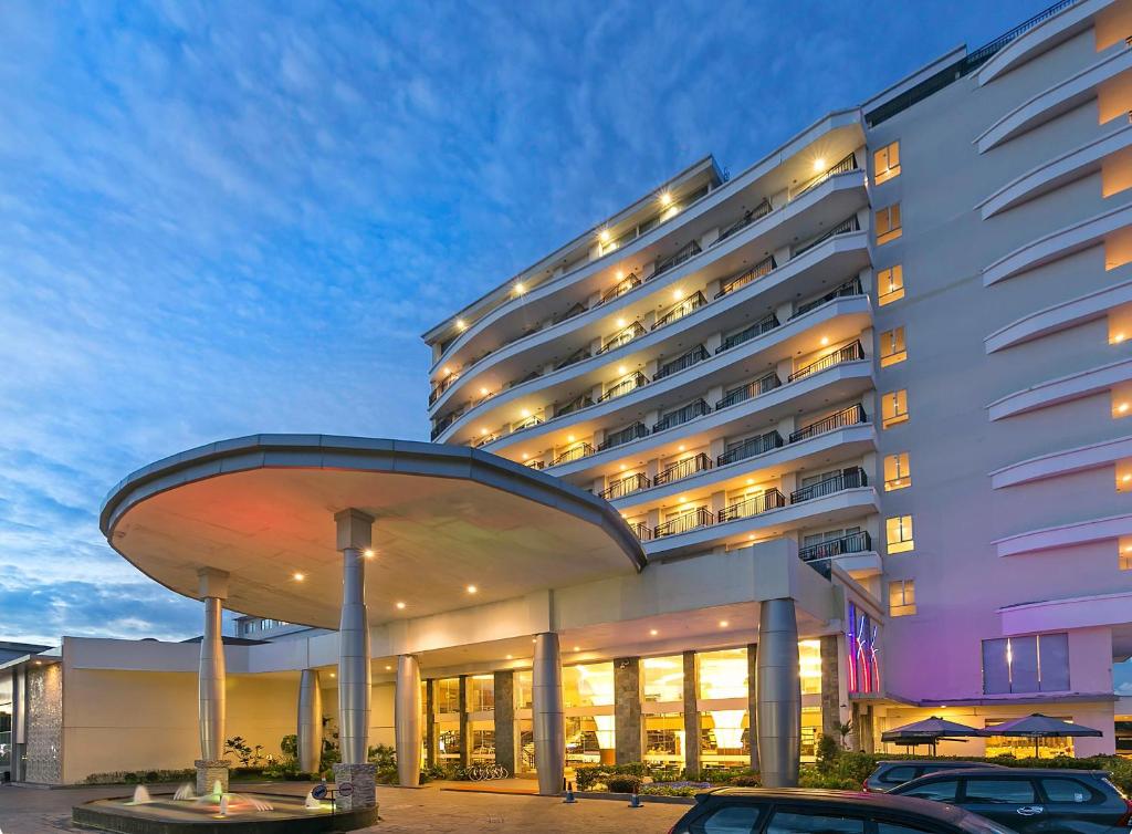 a large building with cars parked in front of it at BW Suite Belitung in Tanjungpandan